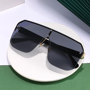 Oversized shield sunglasses with grey gradient lenses and silver rivet studs on marble
