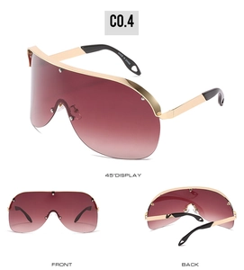 Detail view of gold shield sunglasses with red-brown gradient lenses and metal frame