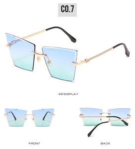Détail de lunettes de soleil carrées sans monture avec verres dégradés bleu-vert et branches dorées