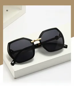 Detail of square oversized sunglasses with gold metal bridge on a modern pedestal