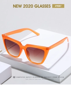 Detail of orange cat eye sunglasses frame with gradient lenses on a display stand