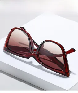 Detail view of the red translucent frame texture and gradient lenses on cat eye sunglasses