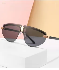 Detail of rimless aviator sunglasses with gray gradient lenses and gold rivets