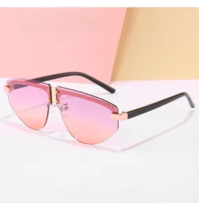 Detail of rimless sunglasses with pink-orange gradient lenses and gold metal nose bridge