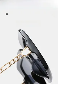 Detail of square sunglasses with black frames and elegant gold chain metal temples
