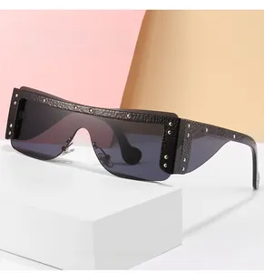Detail of oversized shield sunglasses with leather texture and silver rivets on a pedestal