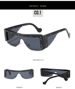 Detail of black oversized shield sunglasses with silver rivet accents and metal nose pads