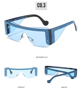 Detailed view of oversized blue wrap sunglasses with denim texture and metal rivets