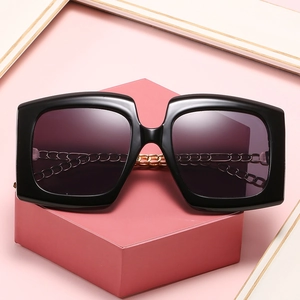 Fashion square cat-eye sunglasses with gold metal chain on pink display stand