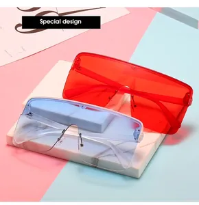 Close-up of oversized shield sunglasses in red and gradient blue on a stylish background