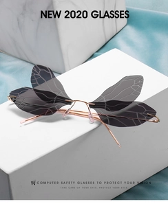Detail of dragonfly wing sunglasses featuring grey gradient lenses and rose gold metal frame