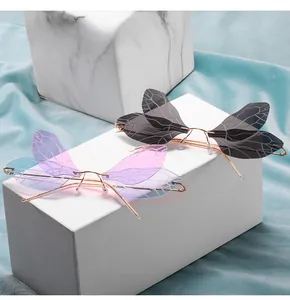 Detail of dragonfly wing shaped rimless sunglasses with purple gradient lenses and gold frame