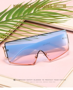 Detail of oversized rimless gradient lenses with gold hinges and palm leaf background