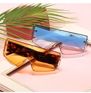 Close-up of oversized geometric sunglasses with unique rivet hinges and ocean tint lenses