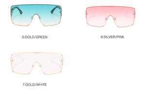 Close-up of oversized shield sunglasses with metal rivets and tortoise texture temples