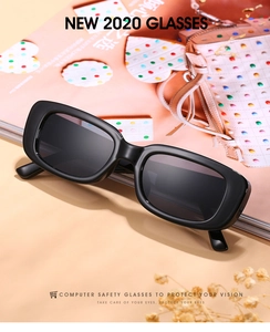Détail de lunettes de soleil ovales noires rétro sur un magazine de mode avec fleurs