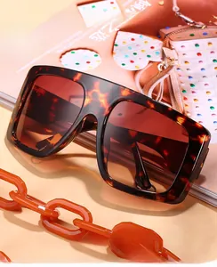 Detail of dark tortoiseshell square sunglasses with orange resin chain and gradient lenses