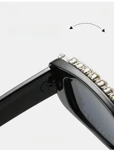 Close-up of durable metal hinge and decorative square rhinestones on black sunglasses
