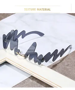 Detail of unique N-shaped wave gray lenses with minimalist gold metal frame accents