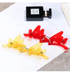 Flat lay of rimless wave-shaped flame sunglasses in red and yellow with golden nose pads
