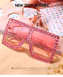Close-up of square pink sunglasses with oversized frames and sparkling rhinestones