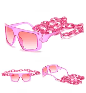 Detailed close-up showing the oversized square pink frames and bold acrylic chain links