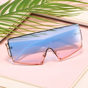 Oversized rimless sunglasses with blue-pink gradient lenses and gold rivet accents