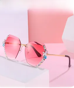 Détail de lunettes de soleil polygonales sans monture avec verres roses et strass