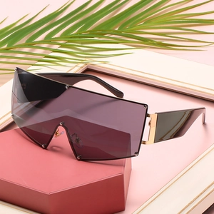 Oversized shield sunglasses with silver stud rivets on pink geometric display stand