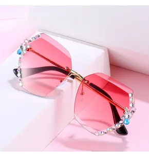 Détail de verres dégradés roses avec strass brillants sur lunettes de soleil sans monture