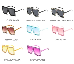Flat lay of oversized rhinestone sunglasses in eight colors with gradient lenses