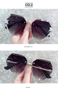 Détail de lunettes de soleil sans monture avec strass, papillon et verres dégradés