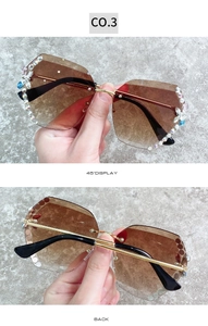 Détail de lunettes de soleil sans monture dégradé marron avec strass sur cadre doré