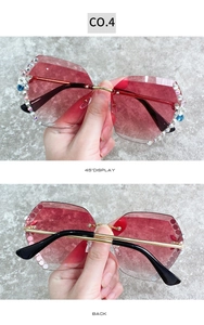 Détail de verres dégradés rouges sans monture avec strass et monture en métal doré