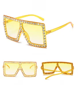 Macro detail of oversized square sunglasses with yellow lenses and rhinestone embellishments