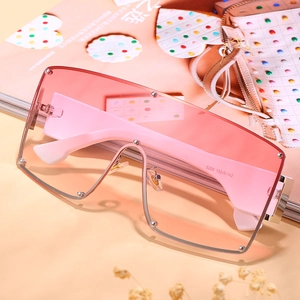 Oversized gradient pink square sunglasses with silver rivets on stylish magazine
