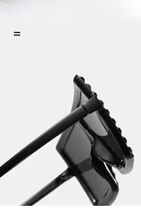 Close-up of black oversized square sunglasses showing the durable hinges and thick frame