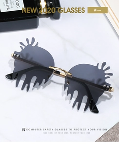 Detailed close-up of grey drip-shaped frameless sunglasses with gold metal temples