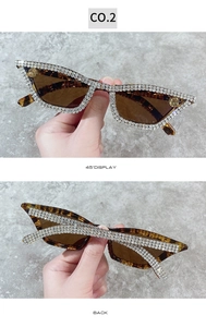 Detail view of tortoiseshell cat-eye sunglasses with hand-set rhinestones and brown lenses