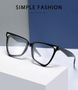 Detail shot of black cat-eye glasses with gold triangle rivets and anti-blue light lenses