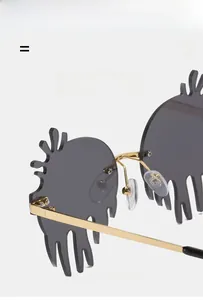 Detail of creative flame-shaped frameless sunglasses with grey lenses and gold metal frames