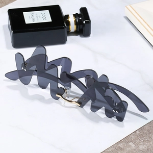 Unique wavy rimless sunglasses with dark grey lenses and golden metal bridges for women