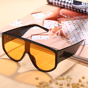 Oversized one-piece sunglasses with black thick frame and vibrant orange lenses