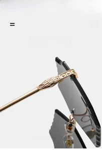 Close-up of frameless sunglasses with scalloped lens edges and gold snake scale temples