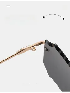 Detail of durable gold metal hinge on rimless square sunglasses with grey lenses
