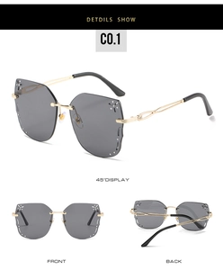 Detailed macro view of rimless rhinestone sunglasses with gold metal temples and grey lenses