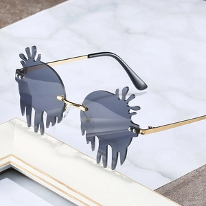 Unique flam-shaped rimless sunglasses with gold metal frame on marble background