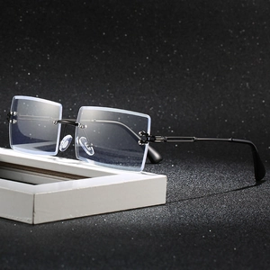 Minimalist square rimless blue light blocking glasses with black metal arms on dark background