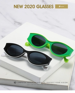 Retro cat-eye small oval sunglasses in black and green frames on marble display