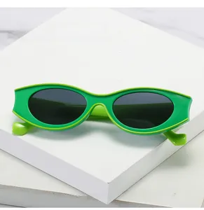 Close-up of vibrant lime green oval sunglasses with dark lenses on white pedestal